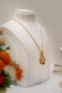 a white mannequin with a gold necklace on it